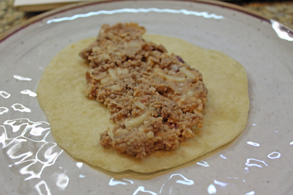 Open tortilla with beef/bean mixture in the middle