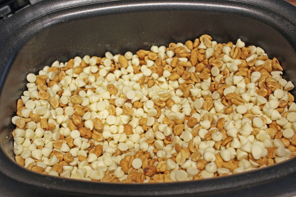 White chocolate chips and peanuts in the crockpot.