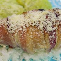 Bacon Ranch Chicken, side view, on a bed of rice with parmesan on top. Sauteed Squash in the back.