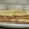 Two halves of the fried bologna grilled cheese stacked on each other.
