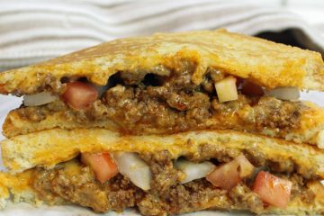 Two halves of a taco grilled cheese stacked on top of each other.