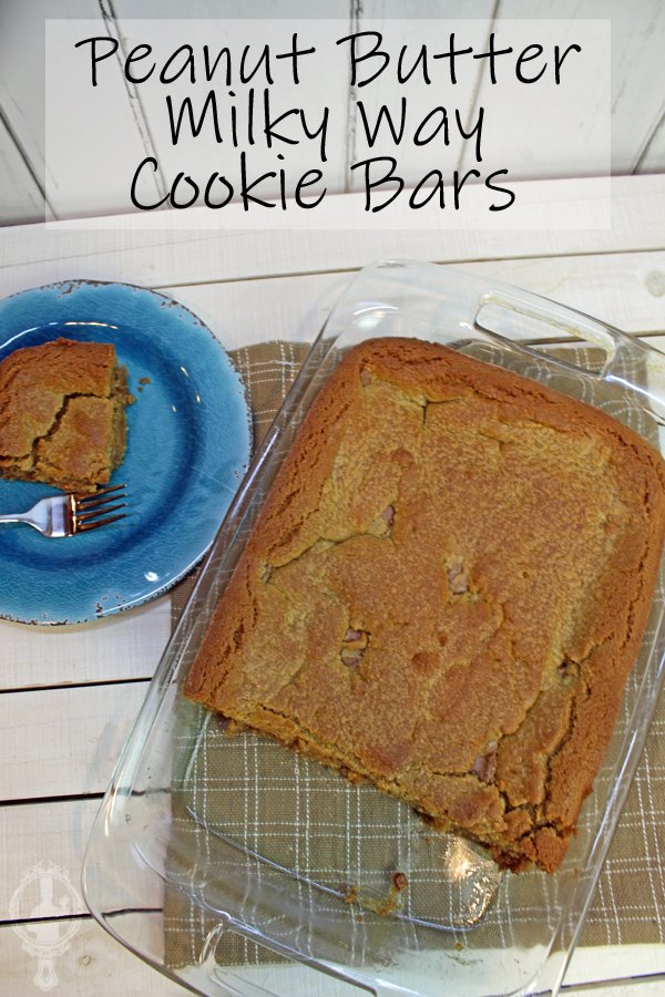 Overhead view with the Peanut Butter Milky Way Cookie Bars in the baking dish on the right. Top left shows a blue plate with a piece of the cooke bar and a fork on it.