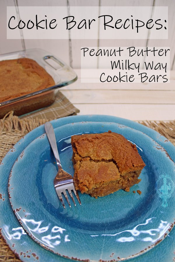 A piece of the cookie bar on a plate with a fork. The baking dish is in the background.