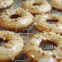 Angled picture of banana bread donuts on a rack.