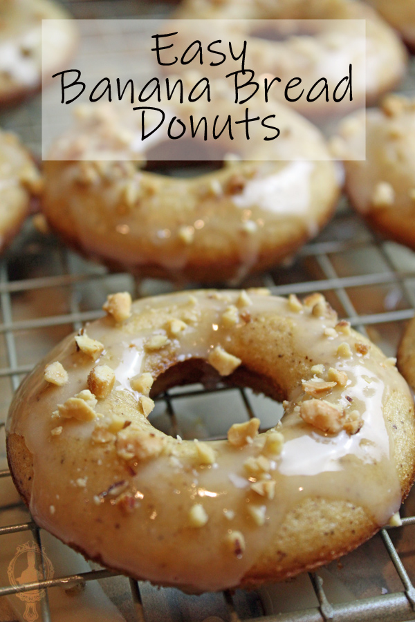 Banana bread donuts with icing and nuts on top resting on a rack.