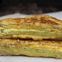 Straight on view of two halves of scrambled egg sandwich.