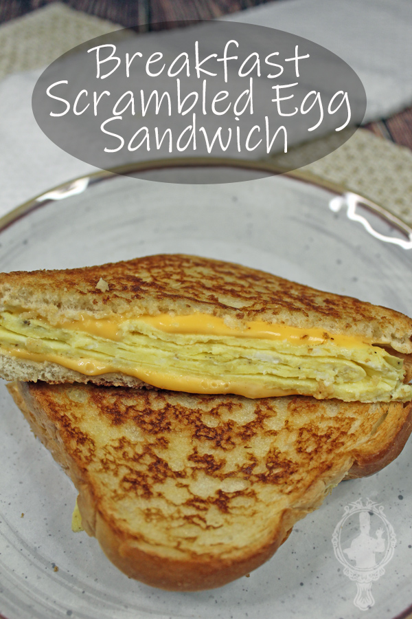 A scrambled egg sandwich cut in half on a plate.