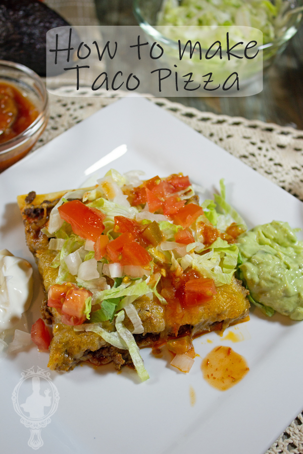 A square piece of taco pizza on a plate with tomato, lettuce and onions on top. Guacamole and sour cream on the side.