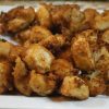 Close up of a plate with a batch of chicken nuggets.