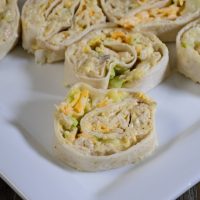 A plate with some sliced chicken salad pinwheels, ready to eat.