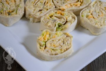 A plate with some sliced chicken salad pinwheels, ready to eat.