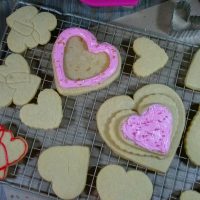 Overhead view of cut out soft sugar cookies on a rack with a couple frosted.
