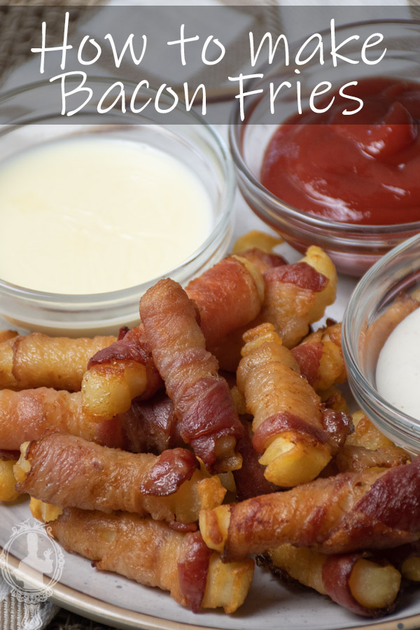 Angled view of a serving of bacon fries with condiments on the side.
