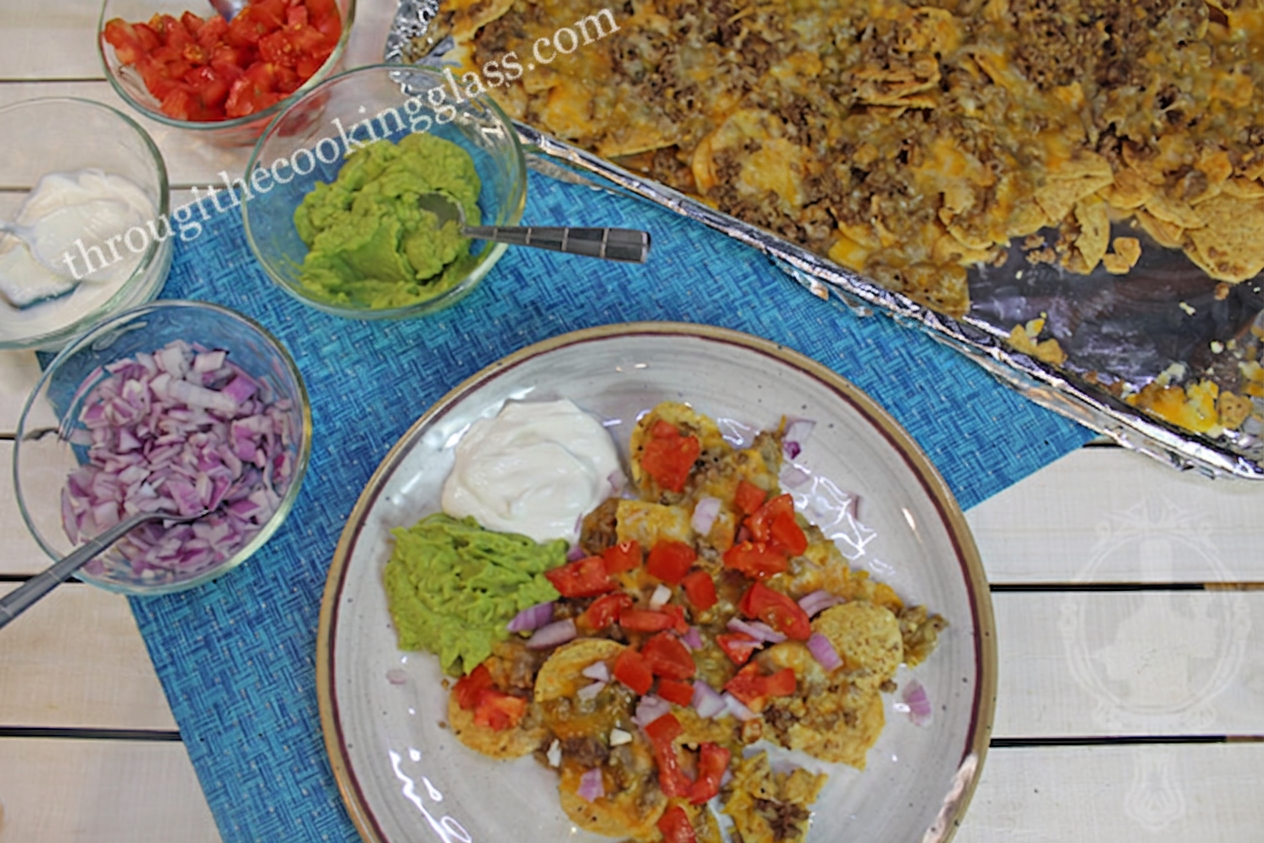 Showing the sheetpan with the base ingredients for the beef nachos and the plate with toppings on the nachos.